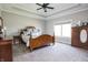 Spacious main bedroom with tray ceiling, featuring a wooden four-poster bed and matching dressers at 1426 Manchester Dr, Danville, IN 46122