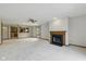 Cozy living room with fireplace, ceiling fan, and a partial view into the kitchen at 15 Northridge Ct, Brownsburg, IN 46112