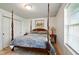 Charming bedroom with a four-poster bed, wood floors, and a light filled window at 155 Suncrest Dr, Greenwood, IN 46143