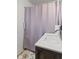 Clean bathroom featuring a patterned shower curtain, a shower grab bar, and a white vanity sink at 17 W Washington St, Mooresville, IN 46158