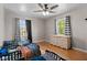 Bedroom featuring ceiling fan, hardwood flooring, and three toddler beds next to a woven dresser at 17 W Washington St, Mooresville, IN 46158