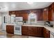 Bright kitchen featuring wood cabinetry, white appliances, and a light countertop, perfect for cooking and entertaining at 17 W Washington St, Mooresville, IN 46158