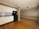 A kitchen with white cabinetry, black appliances, and hardwood flooring adjacent to the dining area at 1705 Witt Rd, Lebanon, IN 46052