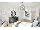Sunlit bedroom features a black dresser, round mirror and unique light fixture at 2215 Boxwood Dr, Greenfield, IN 46140