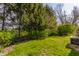 Lush backyard with green lawn, mature trees, and chain link fence, offering privacy at 2236 Calaveras Way, Indianapolis, IN 46240