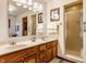 Bathroom featuring a double sink vanity, a framed mirror, and a glass-enclosed shower at 2236 Calaveras Way, Indianapolis, IN 46240