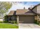 Lovely townhouse showcasing a two-car garage, stone details, and tidy landscaping at 2236 Calaveras Way, Indianapolis, IN 46240