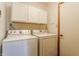 Functional laundry room with washer, dryer, storage cabinets, and a convenient door at 2236 Calaveras Way, Indianapolis, IN 46240
