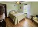 Well-lit bedroom with hardwood floors, ceiling fan, and comfortable seating area at 2405 Sycamore St, Columbus, IN 47201