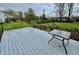 Outdoor deck with a table, surrounded by lush greenery and landscaping at 2405 Sycamore St, Columbus, IN 47201