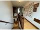 Hallway with hardwood floors, quilt on the wall, and a staircase at 2405 Sycamore St, Columbus, IN 47201