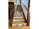 Close up of staircase decorated with leaf-patterned wallpaper and stuffed animals at 2405 Sycamore St, Columbus, IN 47201