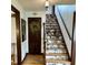 Staircase with decorative wall paper, wooden railing, and a wreath on the door at 2405 Sycamore St, Columbus, IN 47201