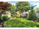 Private backyard with green lawn, garden beds, and mature trees provides a serene setting at 2512 E 57Th St, Indianapolis, IN 46220
