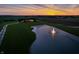 Expansive aerial view of the estate showcasing the pond with a fountain and lush green lawn at sunset at 2575 W 100 S, Franklin, IN 46131