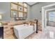 Modern bathroom with a white soaking tub, wood-look tile, and decoratively framed artwork at 2575 W 100 S, Franklin, IN 46131