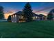 Beautiful home exterior highlighting the sprawling lawn, serene pond, and sunset at 2575 W 100 S, Franklin, IN 46131