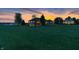 The home is surrounded by well-manicured landscaping and a lush green lawn with a vivid sunset at 2575 W 100 S, Franklin, IN 46131