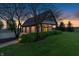 Detached garage with well-maintained landscaping and exterior lights, bathed in the glow of sunset at 2575 W 100 S, Franklin, IN 46131