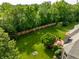 Aerial view of a backyard oasis with a deck, firepit, and mature trees providing shade and privacy at 269 Manchester Ct, Noblesville, IN 46060