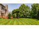 Spacious, well-manicured backyard featuring a deck, brick chimney, and mature trees for privacy at 269 Manchester Ct, Noblesville, IN 46060