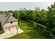Large backyard with mature trees and a basketball hoop near a two-car garage at 269 Manchester Ct, Noblesville, IN 46060