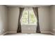 An empty bedroom with neutral walls and carpet features a large window with backyard views at 269 Manchester Ct, Noblesville, IN 46060