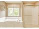 Bright main bathroom showcasing a large soaking tub, separate shower, and a window overlooking the backyard at 269 Manchester Ct, Noblesville, IN 46060