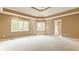 Spacious main bedroom with a tray ceiling, large windows offering scenic views, and neutral tones throughout at 269 Manchester Ct, Noblesville, IN 46060