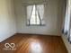 A bright bedroom featuring hardwood floors and vintage style striped curtains at 302 E Main St, Greenfield, IN 46140