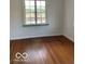 A serene bedroom featuring hardwood floors and a window that lets in natural light at 302 E Main St, Greenfield, IN 46140