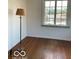 Bedroom with hardwood floors illuminated by natural light from the window next to a vintage floor lamp at 302 E Main St, Greenfield, IN 46140