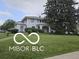 Traditional home with manicured lawn and mature trees on a sunny day at 302 E Main St, Greenfield, IN 46140