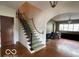 Spacious foyer featuring hardwood floors, staircase with unique rope railing, and decorative lighting at 302 E Main St, Greenfield, IN 46140
