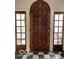 A solid wood front door flanked by sidelights over black and white checkerboard flooring at 302 E Main St, Greenfield, IN 46140