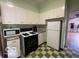 Retro kitchen features white appliances, green tile trim and a checkerboard floor at 302 E Main St, Greenfield, IN 46140