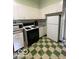 Retro kitchen features white appliances, green tile trim and a checkerboard floor at 302 E Main St, Greenfield, IN 46140