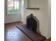Living room with hardwood floors, fireplace, neutral paint, and a large window at 302 E Main St, Greenfield, IN 46140