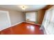 This is a bedroom with red floors, tan walls and a window with blinds and curtains allowing light at 319 N Ridgeview Dr, Indianapolis, IN 46219