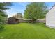 Home's backyard featuring lush green grass and a wooden shed at 327 S Biltmore Ave, Indianapolis, IN 46241