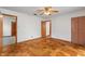 Bedroom with hardwood floors, ceiling fan, and two entryways with doors at 327 S Biltmore Ave, Indianapolis, IN 46241