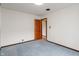 Spacious bedroom featuring blue carpet and a wooden door at 327 S Biltmore Ave, Indianapolis, IN 46241