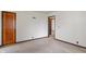 Neutral carpeted bedroom with baseboard trim and a wood paneled interior door at 327 S Biltmore Ave, Indianapolis, IN 46241