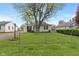 The home's front yard is enclosed by a classic chainlink fence and mature trees at 327 S Biltmore Ave, Indianapolis, IN 46241