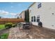 Backyard stone patio with outdoor table and chairs, and lush landscaping at 3430 Burlingame Blvd, Westfield, IN 46074