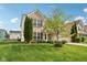 A view of the home's exterior with a lush green lawn and mature tree at 3430 Burlingame Blvd, Westfield, IN 46074