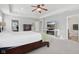 Bright main bedroom features a decorative ceiling fan, dresser, TV and an ensuite bathroom at 3430 Burlingame Blvd, Westfield, IN 46074