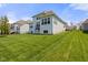 Expansive green backyard with a view of the house featuring multiple windows and a small deck at 3678 Sugar Pine Ln, Zionsville, IN 46077