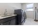 Well-equipped laundry room featuring modern washer and dryer, granite countertops, and ample storage at 3678 Sugar Pine Ln, Zionsville, IN 46077
