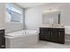 Well-lit bathroom with a soaking tub, granite counters, dark wood cabinets, and neutral wall colors at 3678 Sugar Pine Ln, Zionsville, IN 46077